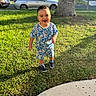 Emiliano joined the competition — help win amazing prizes! toddler, child, smiling, grass, outdoor, sunlight, tree, sidewalk, blue_clothing, patterned_clothing, shorts, shoes, happy, person, daytime, suburb, car, nature, portrait, standing