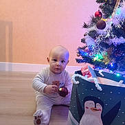Alexandru participe au concours pour gagner de l'argent avec cette photo : baby, celebration, child, christmas_tree, cute, decorations, festive, floor, gift_bag, holiday, holiday_season, home, indoor, lights, ornament, pajamas, penguin, present, smiling, toddler