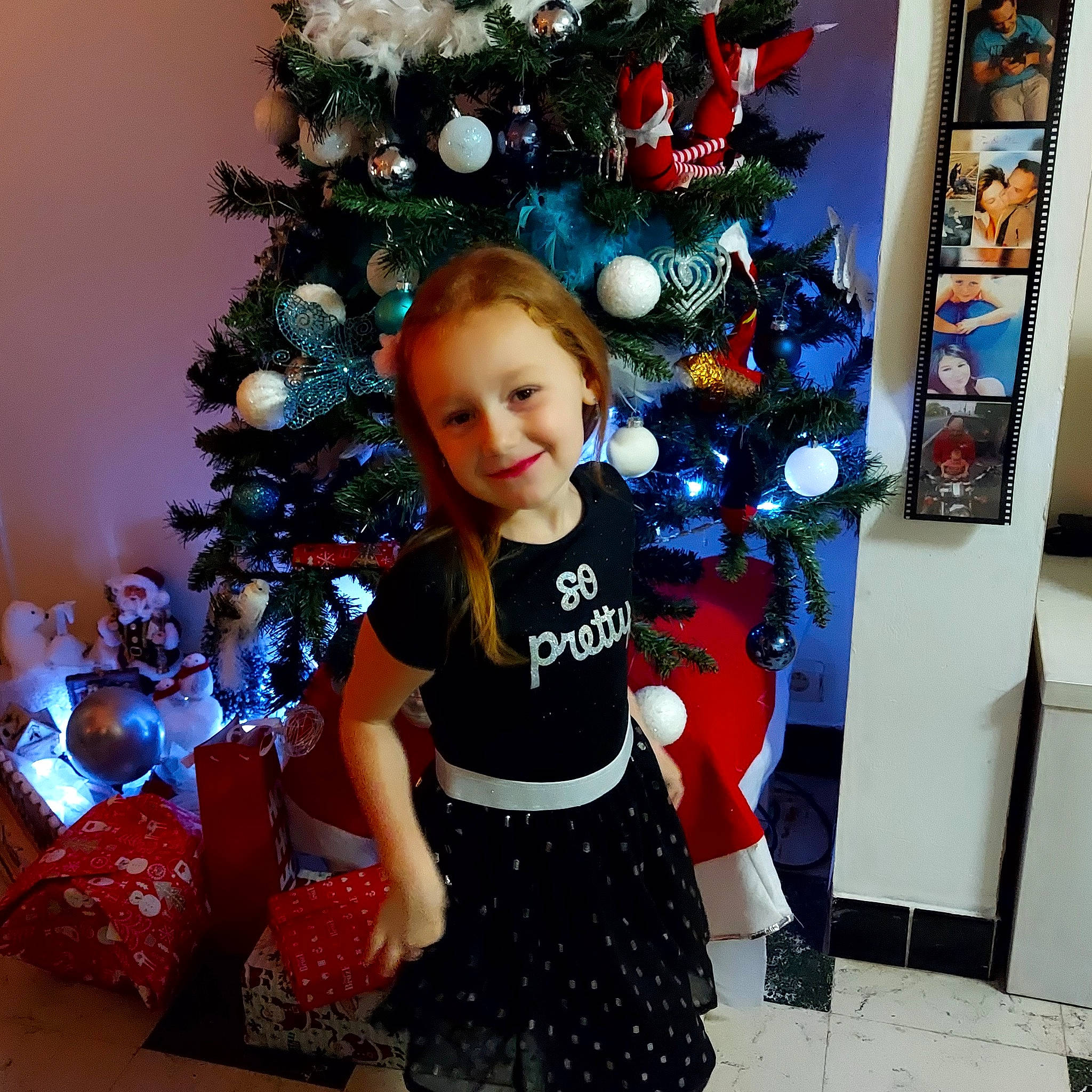 Léa participe au concours pour gagner de l'argent avec cette photo : baby_toddler_clothing, blue, christmas, christmas_decoration, christmas_ornament, christmas_tree, event, evergreen, fun, happy, holiday, holiday_ornament, joy, ornament, person, plant, red, sleeve, smile, standing