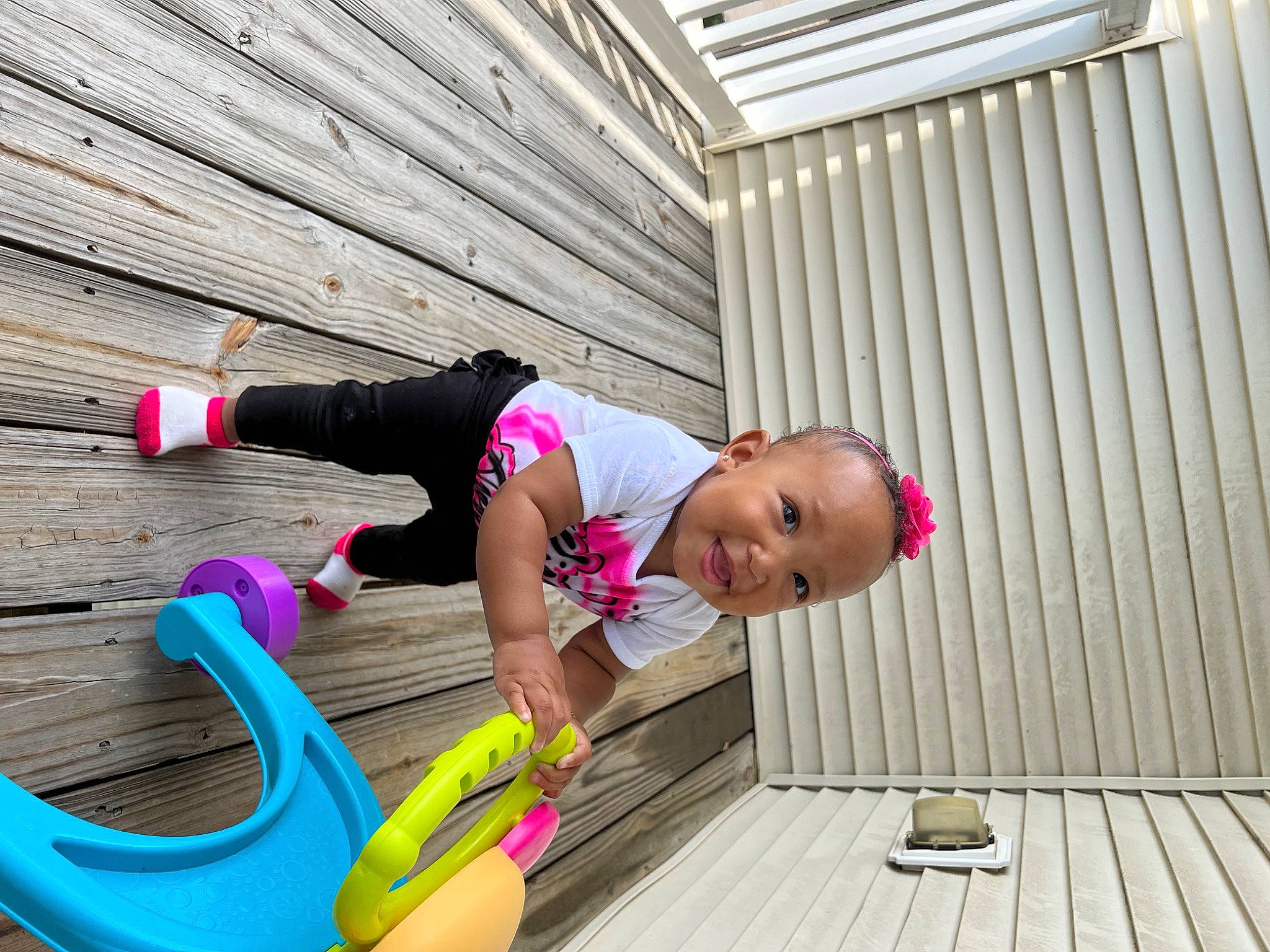 Kind is registered to the contest to win money with this photo: active_pants, fun, happy, hardwood, hat, human_leg, knee, leg, leisure, magenta, person, purple, recreation, sandal, shorts, sitting, sportswear, thigh, toddler, wood