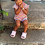 child, girl, pigtails, smile, concrete, steps, door, screen_door, bracelet, slippers, colorful_clothing, outdoor, pose, cute, happy, young_child, casual, sitting, playful, portrait