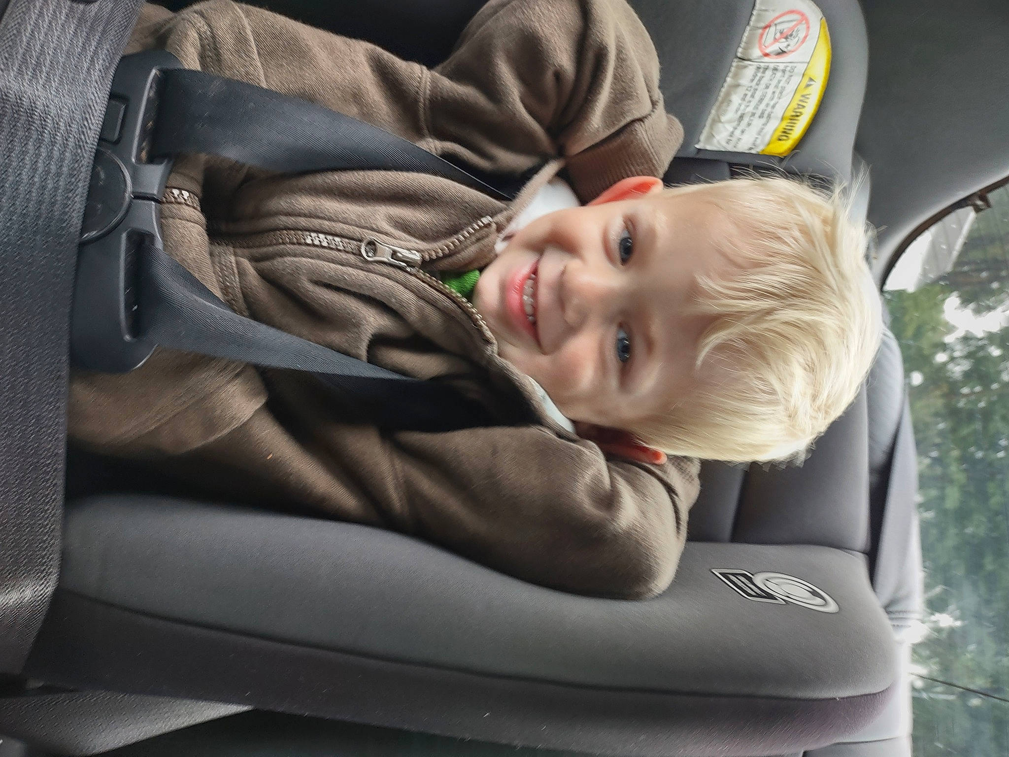 Kai is registered to the contest to win money with this photo: auto_part, automotive_design, baby, baby_carriage, baby_products, car_seat, car_seat_cover, comfort, family_car, fun, happy, hat, joy, motor_vehicle, person, seat_belt, smile, steering_part, toddler, tree