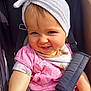 toddler, child, smiling, headwrap, pink_clothing, stroller, seatbelt, baby, cute, happy, sunlight, portrait, face, baby_clothes, infant, outdoor, cute_expression, baby_girl, child_seat, closeup