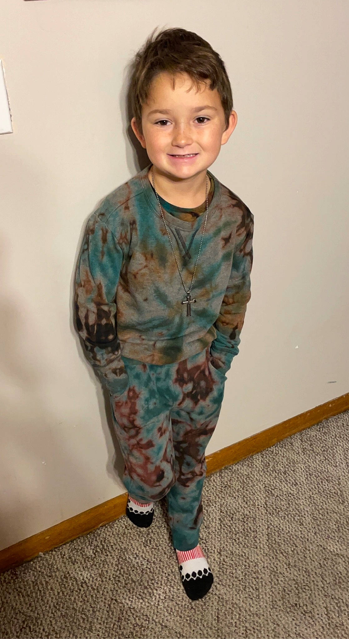 Sawyer is registered to the contest to win money with this photo: arm, baby_toddler_clothing, child, electric_blue, face, fashion_design, flooring, happy, human_leg, joy, knee, leg, military_camouflage, pattern, person, sitting, sleeve, smile, standing, t_shirt