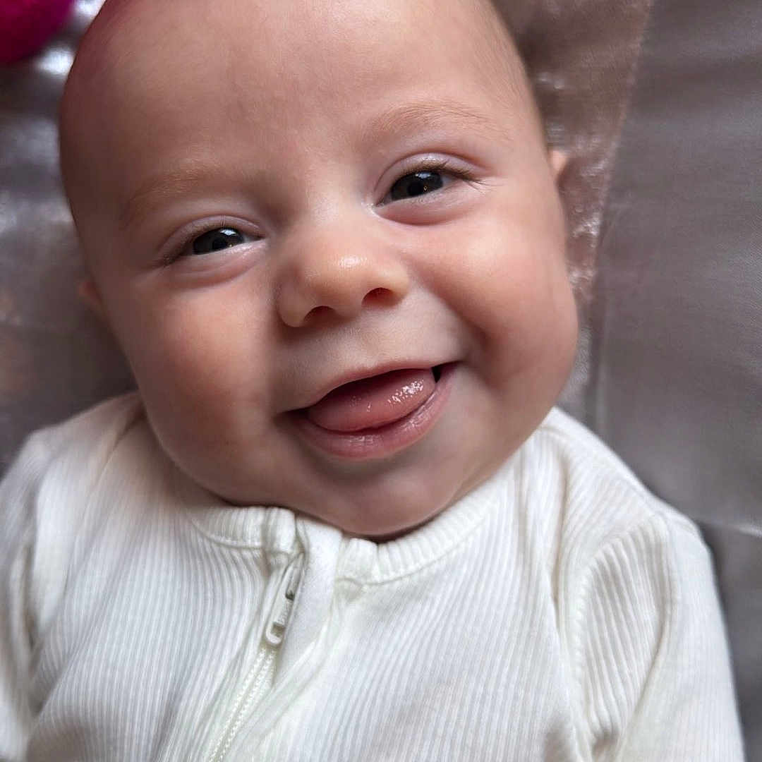Jersie Lee is registered to the contest to win money with this photo: baby, child, closeup, cozy, cute, eyes, fabric, face, happy, head, infant, pink, pocket, portrait, skin, smiling, soft_texture, tongue_out, white_clothing, zipper