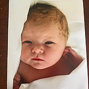 Quinn is registered to the contest to win money with this photo: baby, newborn, infant, face, blanket, curly_hair, skin, closeup, portrait, sleepy, wrapped, peaceful, cute, child, human, soft, newborn_baby, resting, indoors, warm
