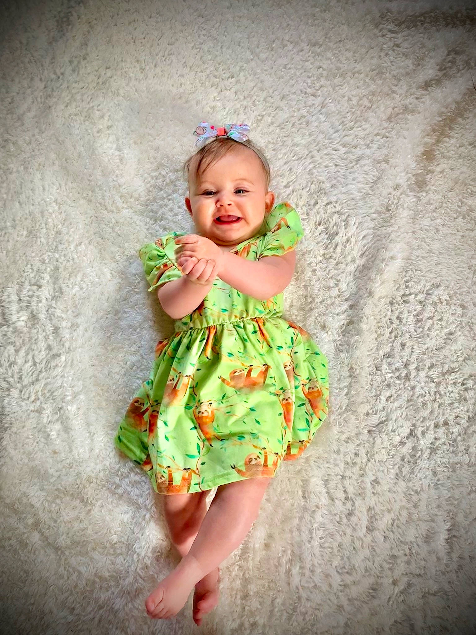 Aislynn is registered to the contest to win money with this photo: baby, child, child_model, dress, fashion_accessory, green, hair_accessory, pattern, person, photo_shoot, photograph, photography, pink, plant, portrait, skin, smile, standing, textile, toddler
