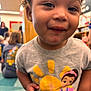 Harlow joined the competition — help win amazing prizes! toddler, child, smile, portrait, indoor, people, clothing, cartoon, tshirt, curly_hair, face, person, young_child, group, background, blurred, happy, kids, colorful, casual