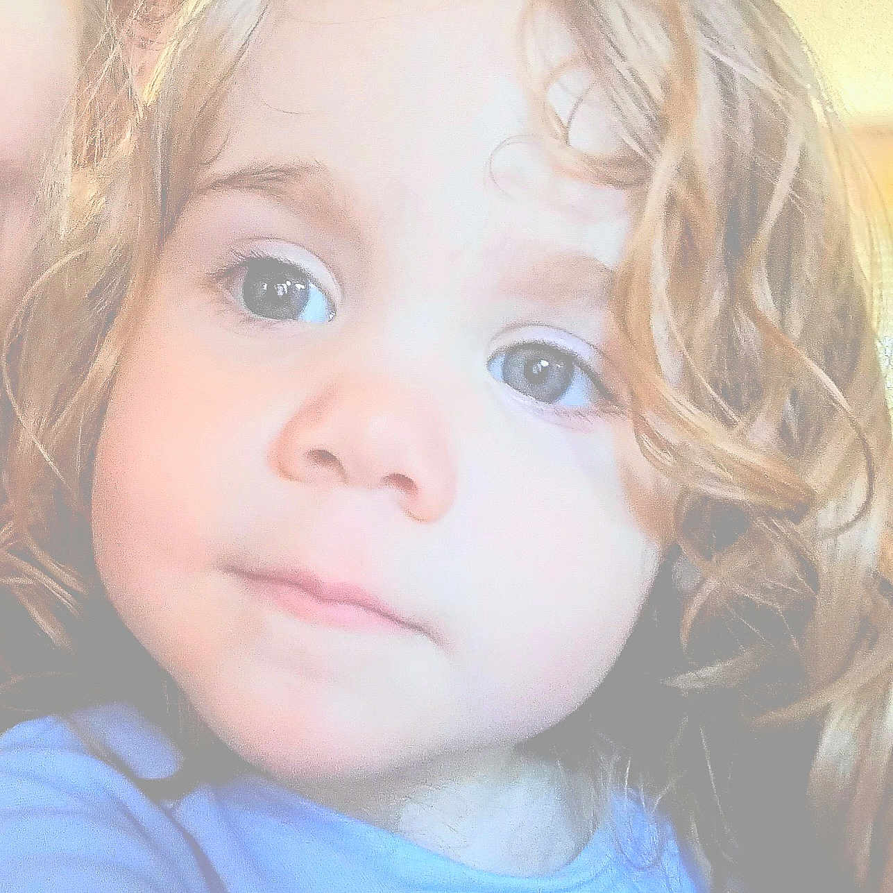 Jazelle is registered to the contest to win money with this photo: baby, blue_shirt, child, closeup, curly_hair, cute, expression, eyes, face, hair, head, human, indoors, looking, person, portrait, skin, soft_lighting, thoughtful, young_child