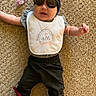 Nala is registered to the contest to win money with this photo: baby, carpet, sunglasses, headband, bib, pacifier, shoes, butterfly, infant, clothing, footwear, person, cute, laying, accessory, casual, indoor, child, fashion, colorful