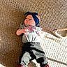 Nala is registered to the contest to win money with this photo: baby, infant, carpet, headband, clothing, pants, shirt, socks, shoes, indoor, sunlight, shadow, floor, cute, child, person, lying_down, colorful, pattern, cozy