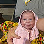 baby, newborn, towel, pink, smile, arm, tattoo, fabric, yellow, pattern, indoor, person, holding, cute, child, face, wrapped, cozy, portrait, infant