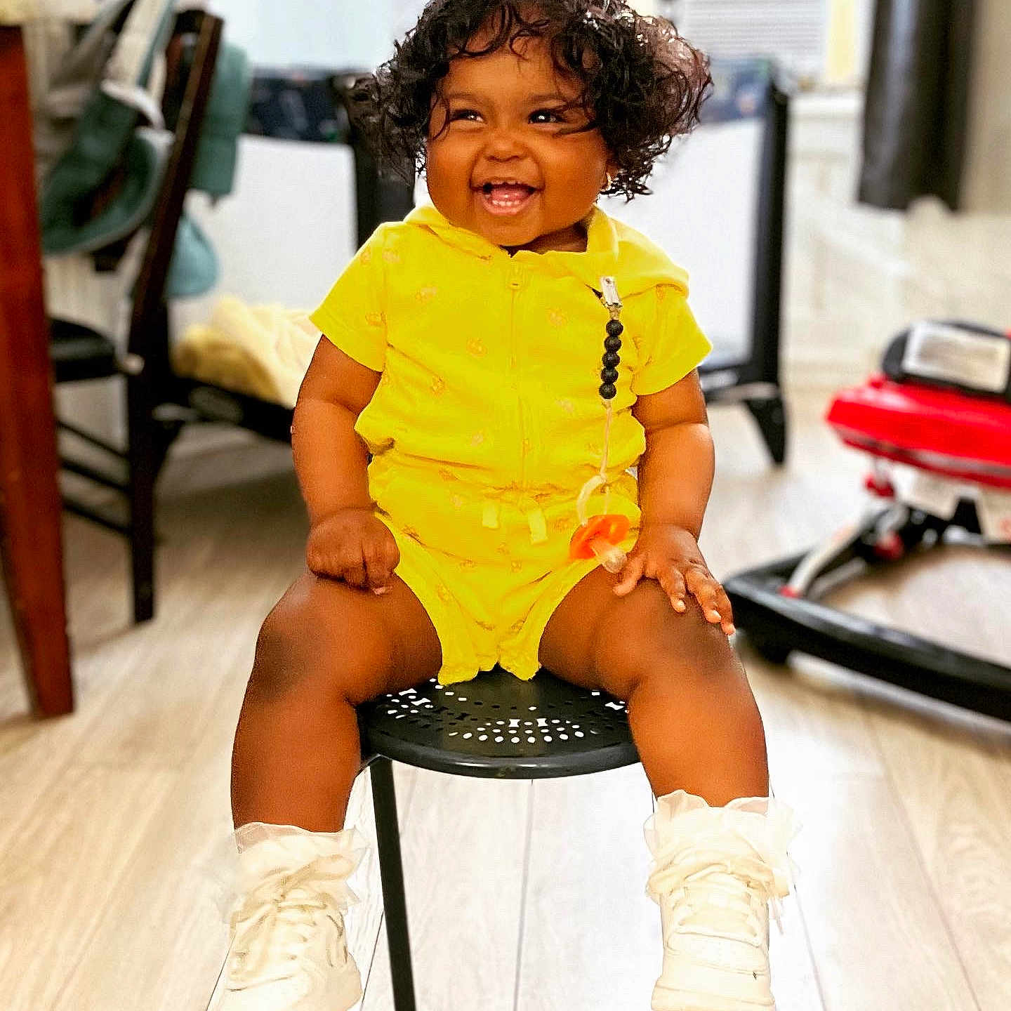 Darla joined the competition — help win amazing prizes! baby, babylaughing, blackhair, clothing, curlyhair, face, hair, happy, head, person, shorts, sitting, sleeve, smile