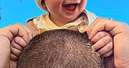 Gabriel joined the competition — help win amazing prizes! baby, child, infant, smiling, laughing, beanie, hat, outdoor, sky, trees, family, adult, parent, selfie, portrait, hands, hair, head, happy, playful