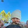 Gabriel is registered to the contest to win money with this photo: baby, child, infant, smiling, face, eyes, hat, beanie, outdoor, sky, blue_sky, trees, autumn, clothing, overalls, sleeves, hands, portrait, closeup, happy