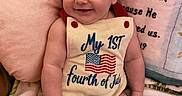 Gabriel joined the competition — help win amazing prizes! baby, blanket, blue, celebration, clothing, cute, flag, fourth_of_july, hand, happy, holiday, indoor, infant, patriotic, pillow, portrait, red, smiling, text, white