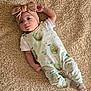 baby, infant, carpet, blanket, headband, bow, pajamas, avocado, pattern, clothing, lying_down, cute, soft_texture, indoors, child, face, socks, toddler, skin, expression