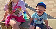 Lucas joined the competition — help win amazing prizes! children, girl, boy, sunglasses, cap, bench, sidewalk, parking_lot, cars, sunny, daylight, casual_clothing, smiling, outdoor, concrete, pavement, water_bottle, playful, shoes, happy