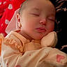baby, sleeping, onesie, heart_pattern, red_blanket, polka_dots, cozy, peaceful, infant, soft_lighting, face, closed_eyes, cute, resting, portrait, child, newborn, fabric, comfort, cuddly