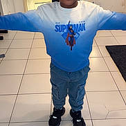 Imran a rejoint le concours — aidez-le/la à gagner de superbes lots ! child, boy, smiling, superman, sweatshirt, blue, pants, cargo_pants, black_shoes, indoor, tile_floor, door, mirror, room, happy, portrait, standing, casual_clothing, young, person