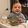 Nathan joined the competition — help win amazing prizes! baby, high_chair, bottle, bowl, spoon, smiling, child, feeding, kitchen, furniture, clothing, bib, happy, indoor, table, person, face, meal, baby_food, dining