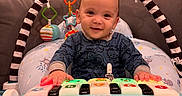 Nathan joined the competition — help win amazing prizes! baby, child, toy, piano, play, smile, couch, living_room, onesie, hanging_toys, cushion, furniture, indoors, person, happy, photography, portrait, infant, home, cute