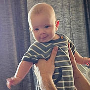 Nico Finnley joined the competition — help win amazing prizes! adult, arm, baby, background, child, curtain, cute, face, hand, happy, holding, human, indoor, infant, onesie, person, portrait, skin, smile, striped_clothing