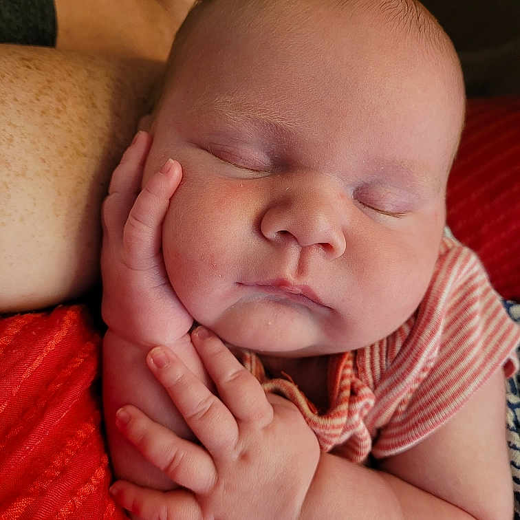 Braelynn joined the competition — help win amazing prizes! baby, sleeping, infant, hand, face, arm, striped_clothing, cushion, red, skin, peaceful, closeup, portrait, child, newborn, resting, soft_light, indoors, human, relaxation