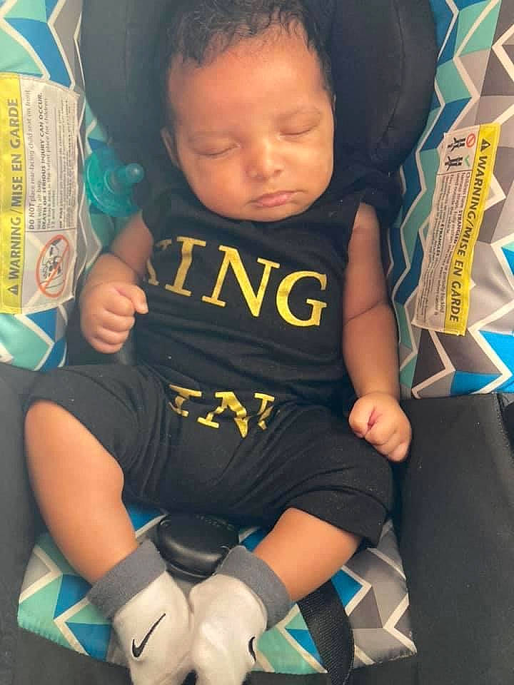 Ezekiel is registered to the contest to win money with this photo: arm, baby, baby_toddler_clothing, black_hair, cool, elbow, eye, finger, hair, hairstyle, hand, happy, knee, leg, neck, person, skin, sleeve, t_shirt, thigh