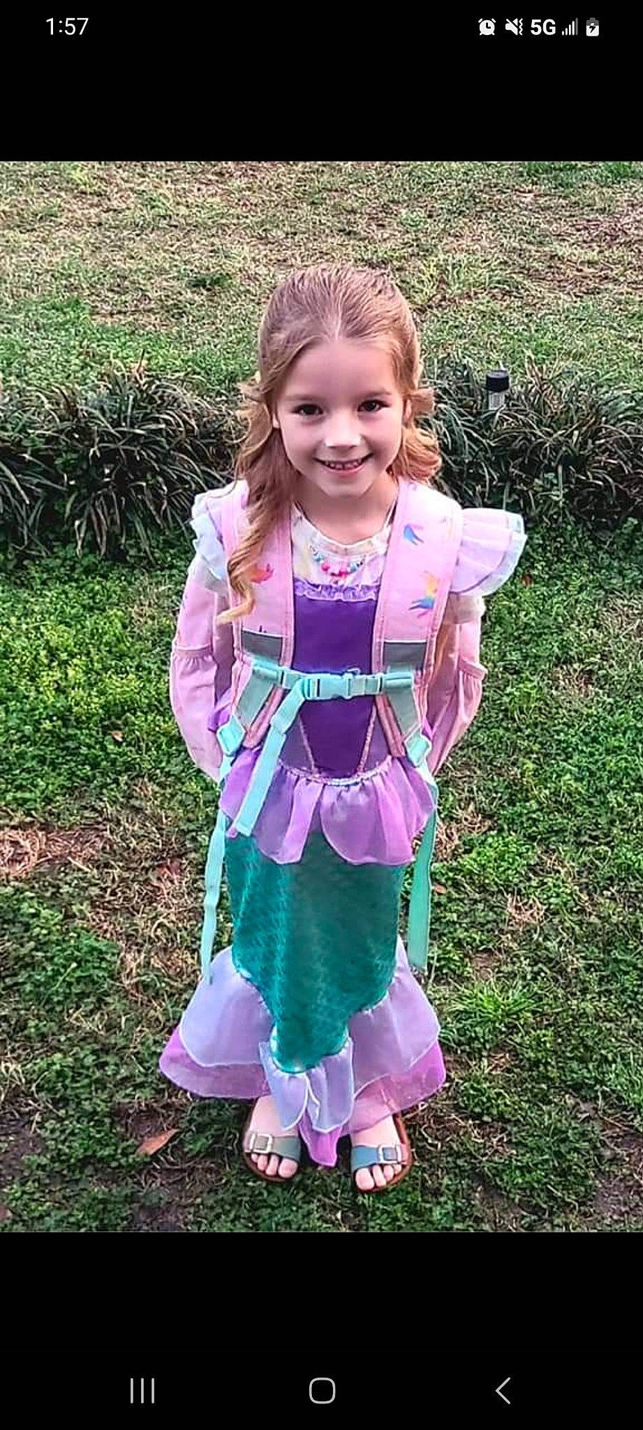 Vivian is registered to the contest to win money with this photo: baby_toddler_clothing, child, dress, eye, face, grass, hair, hairstyle, happy, head, joy, outerwear, pattern, people_in_nature, person, pink, plant, purple, sleeve, smile