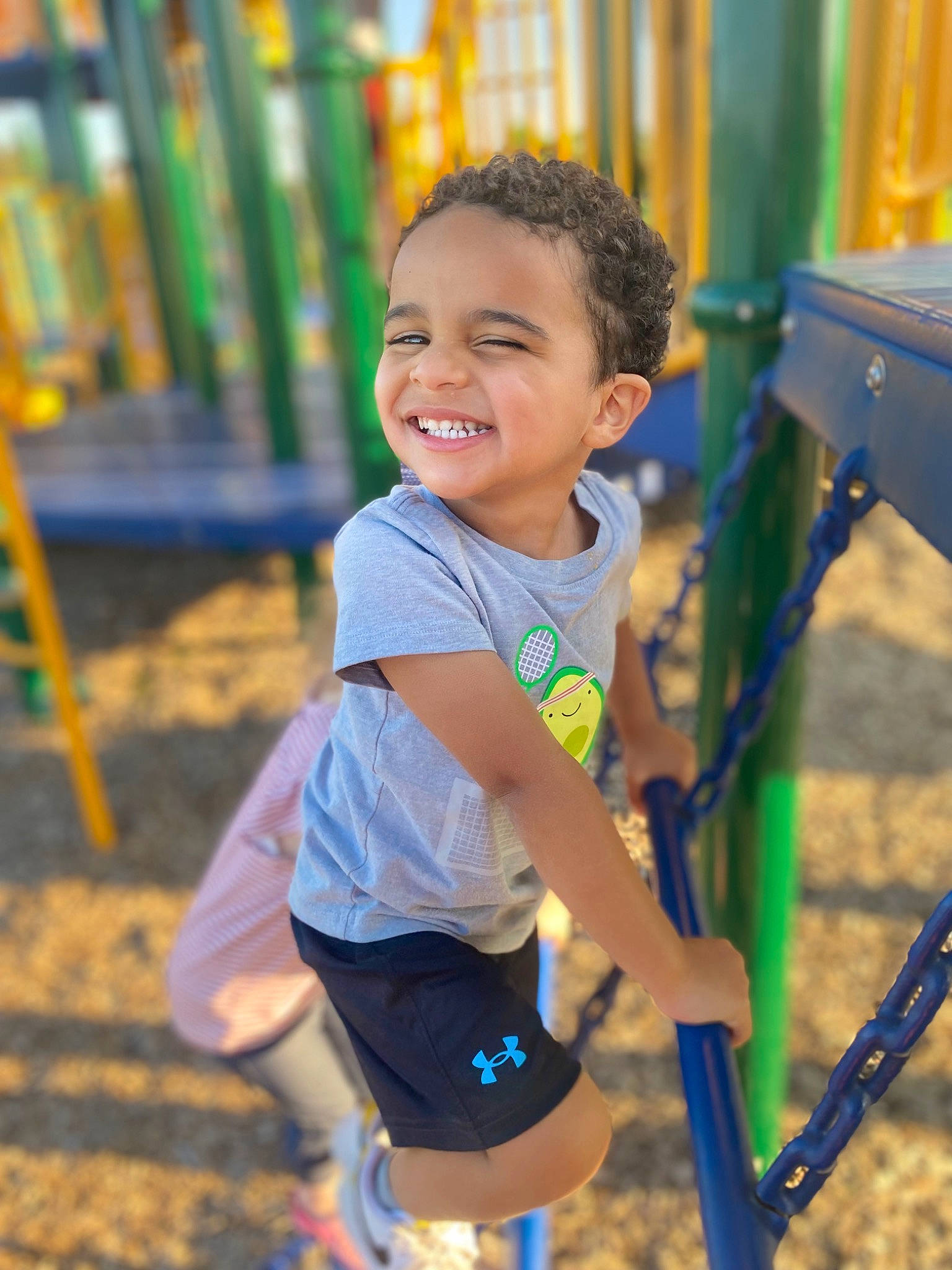 Jabari is registered to the contest to win money with this photo: baby_toddler_clothing, child, city, electric_blue, facial_expression, fun, grass, happy, joy, leisure, outdoor_play_equipment, people_in_nature, person, play, playground, public_space, recreation, sleeve, smile, swing