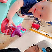 Xavier joined the competition — help win amazing prizes! baby, child, young_adult, person, smile, cap, baby_walker, toy, indoor, floor, chair, clothing, face, furniture, playful, happy, man, infant, headwear, casual