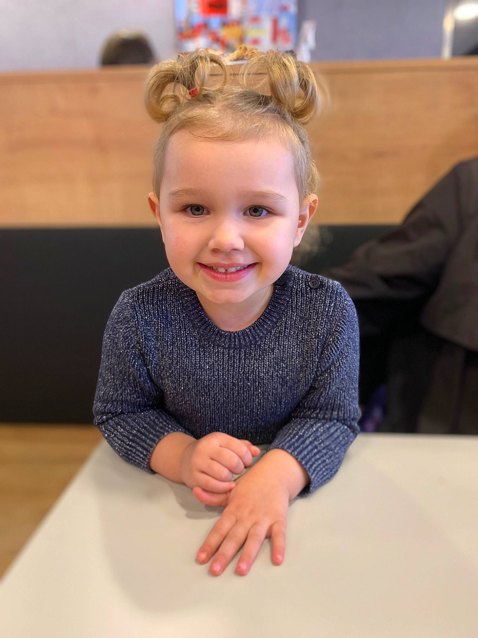 Ambre participe au concours pour gagner de l'argent avec cette photo : baby_toddler_clothing, blond, chair, cheek, eye, fashion_accessory, flooring, fun, happy, headpiece, jewellery, joy, neck, person, room, sitting, sleeve, smile, t_shirt, table