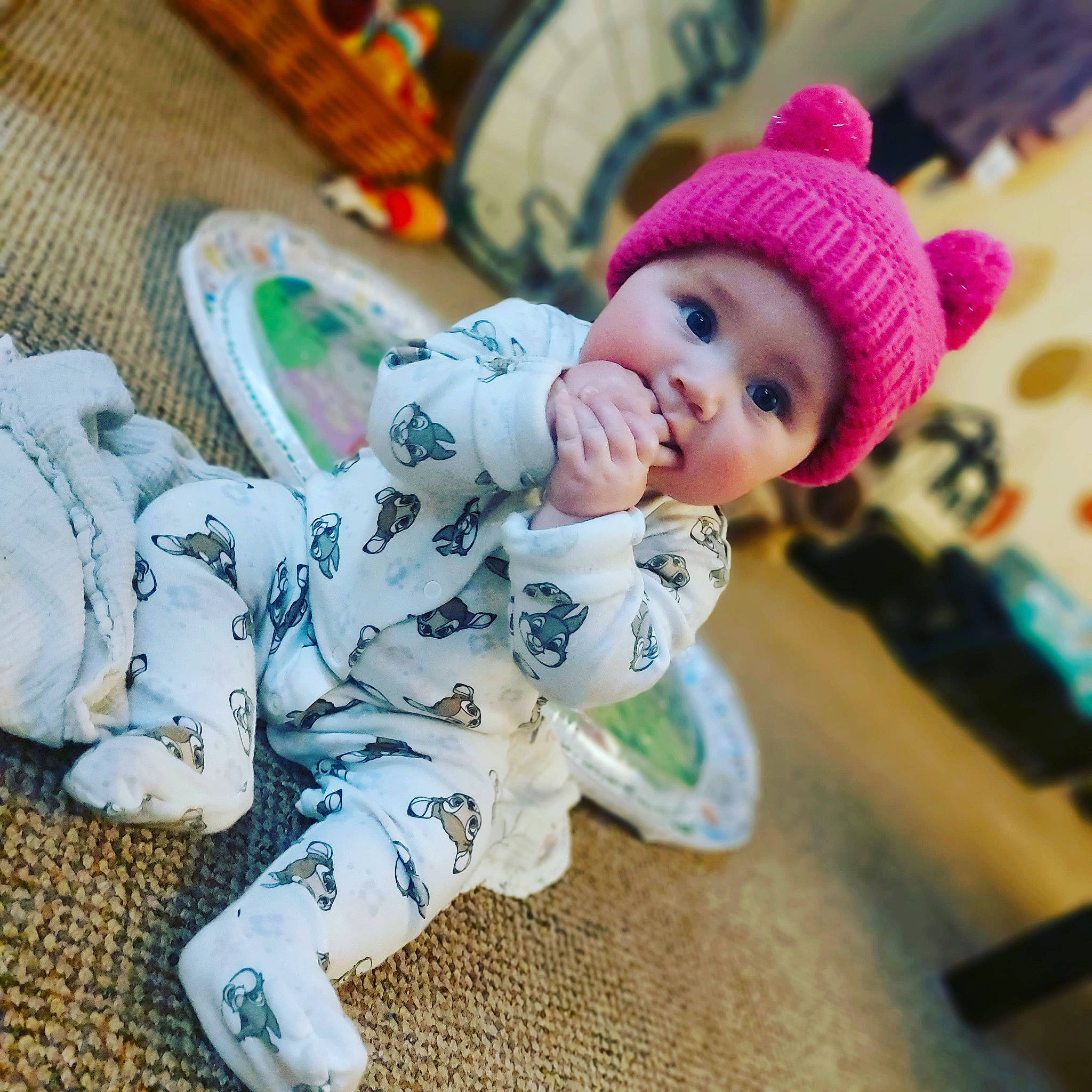 Cara is registered to the contest to win money with this photo: baby, baby_toddler_clothing, cap, cheek, child, comfort, cool, eye, face, flooring, fun, happy, headgear, headwear, knit_cap, leisure, mammal, person, sitting, sleeve