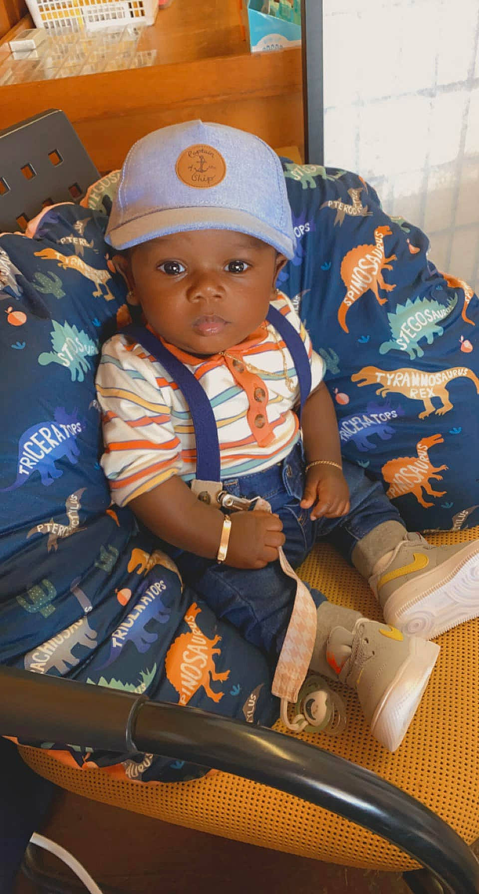 Cannon is registered to the contest to win money with this photo: baby, baby_products, baby_toddler_clothing, bag, baseball_cap, cap, child, electric_blue, fashion_accessory, fun, headwear, luggage_and_bags, pattern, person, personal_protective_equipment, room, shorts, sitting, sleeve, t_shirt