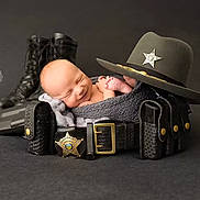 Jonathan is registered to the contest to win money with this photo: newborn, baby, sleeping, police, boots, sheriff_hat, belt, law_enforcement, portrait, black_background, wrapped, cute, infant, peaceful, props, studio_photo, smiling, headgear, leather, uniform