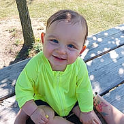 Phoenix joined the competition — help win amazing prizes! baby, child, smile, blue_eyes, neon_jacket, outdoor, bench, wood, tattoo, sunlight, shadow, grass, tree, hand, person, happy, sitting, skin, casual_clothing, nature