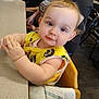baby, child, high_chair, yellow_bib, table, indoor, person, face, blue_eyes, wooden_chair, clothing, cute, hands, seated, carpet, adult, background, skin, expression, hair