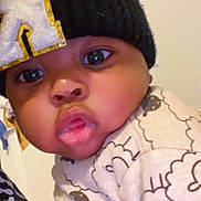 Kionjae is registered to the contest to win money with this photo: baby, child, face, hat, knit_hat, pout, curious, indoors, close_up, clothing, patterned_clothing, cute, wide_eyes, warm_clothing, infant, person, portrait, young_child, headwear, expression