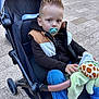 Aloïs participe au concours pour gagner de l'argent avec cette photo : toddler, child, stroller, pacifier, blanket, giraffe_pattern, outdoor, pavement, casual_clothing, jacket, hoodie, jeans, shoes, baby, young_child, person, seated, toy, spiky_hair, daylight