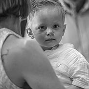 Aloïs a rejoint le concours — aidez-le/la à gagner de superbes lots ! child, toddler, person, adult, black_and_white, portrait, face, looking, expression, clothing, short_hair, holding, background, blurred, indoor, human, people, closeup, interaction, emotion