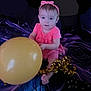 baby, child, pink_dress, headband, balloon, gold_ribbon, sitting, curious, indoors, blanket, foot, celebration, portrait, toddler, smile, face, person, cute, playing, happy