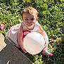 toddler, child, balloon, grass, sunlight, dress, outdoor, nature, happy, smile, cute, baby, one_person, sitting, greenery, sock, concrete, daylight, playful, portrait