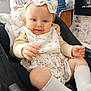 Elodie joined the competition — help win amazing prizes! baby, child, car_seat, bow, socks, bib, indoor, people, woman, man, glasses, chair, blanket, floral, wallpaper, fireplace, furniture, smiling, cute, family