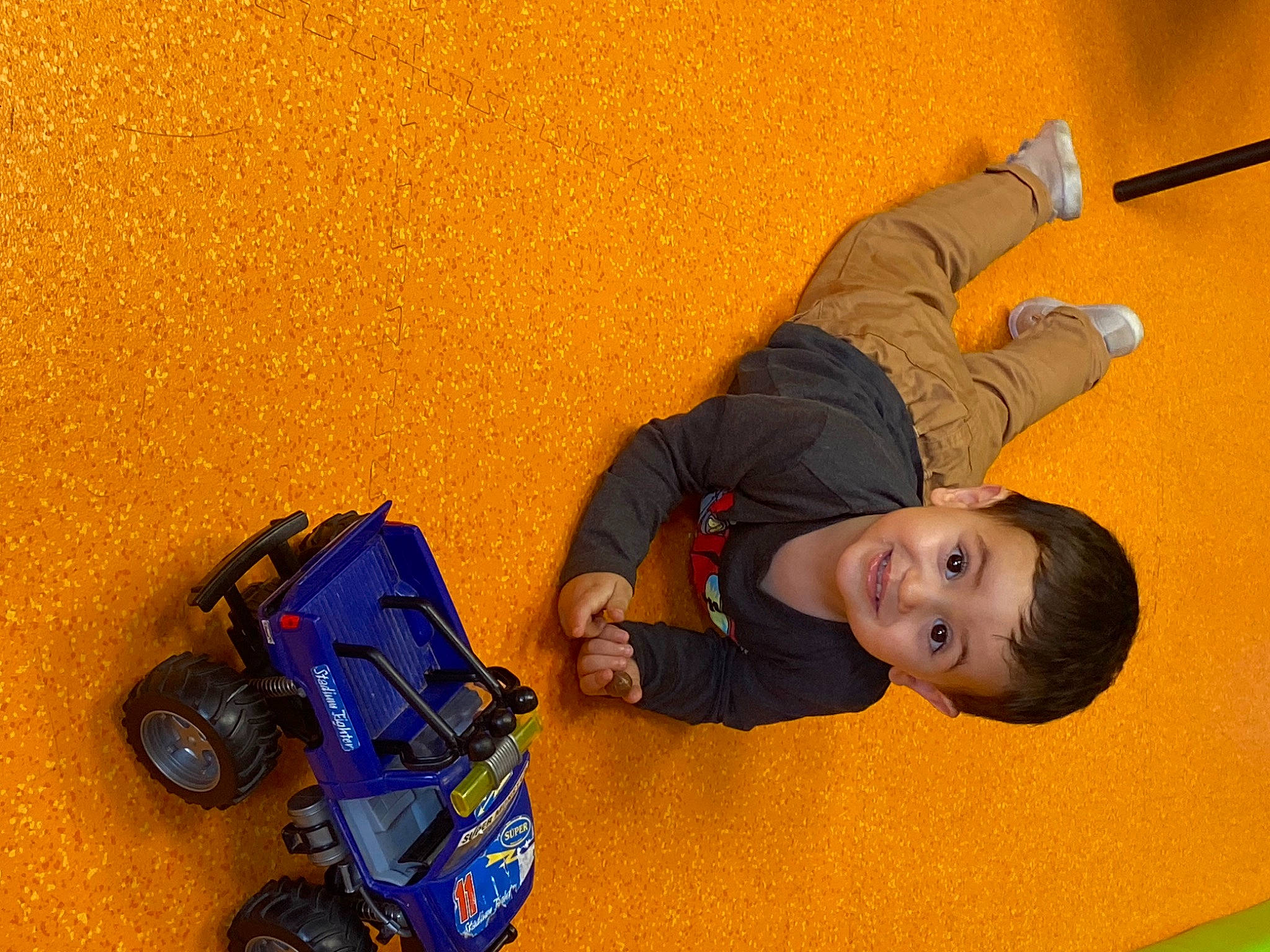 Enzo participe au concours pour gagner de l'argent avec cette photo : ceiling, child, electric_blue, flooring, fun, joy, leisure, machine, person, play, recreation, rolling, room, shoe, smile, sneakers, tire, toddler, toy_vehicle, vehicle