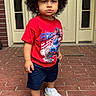 Namari joined the competition — help win amazing prizes! toddler, child, curly_hair, red_tshirt, graphic_tee, navy_shorts, white_shoes, brick_porch, door, outdoor, standing, casual_clothing, portrait, person, young_child, expression, curious, serious, footwear, sidewalk