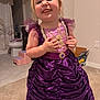 child, girl, dress, purple, indoor, carpet, face, expression, playful, smile, hand, person, furniture, bathroom, toilet, box, curtain, step_stool, headband, earrings