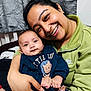 woman, baby, smile, portrait, indoor, clothing, sweater, lion_design, person, happy, face, hand, curtain, cozy, family, affection, holding, closeup, casual_wear, love
