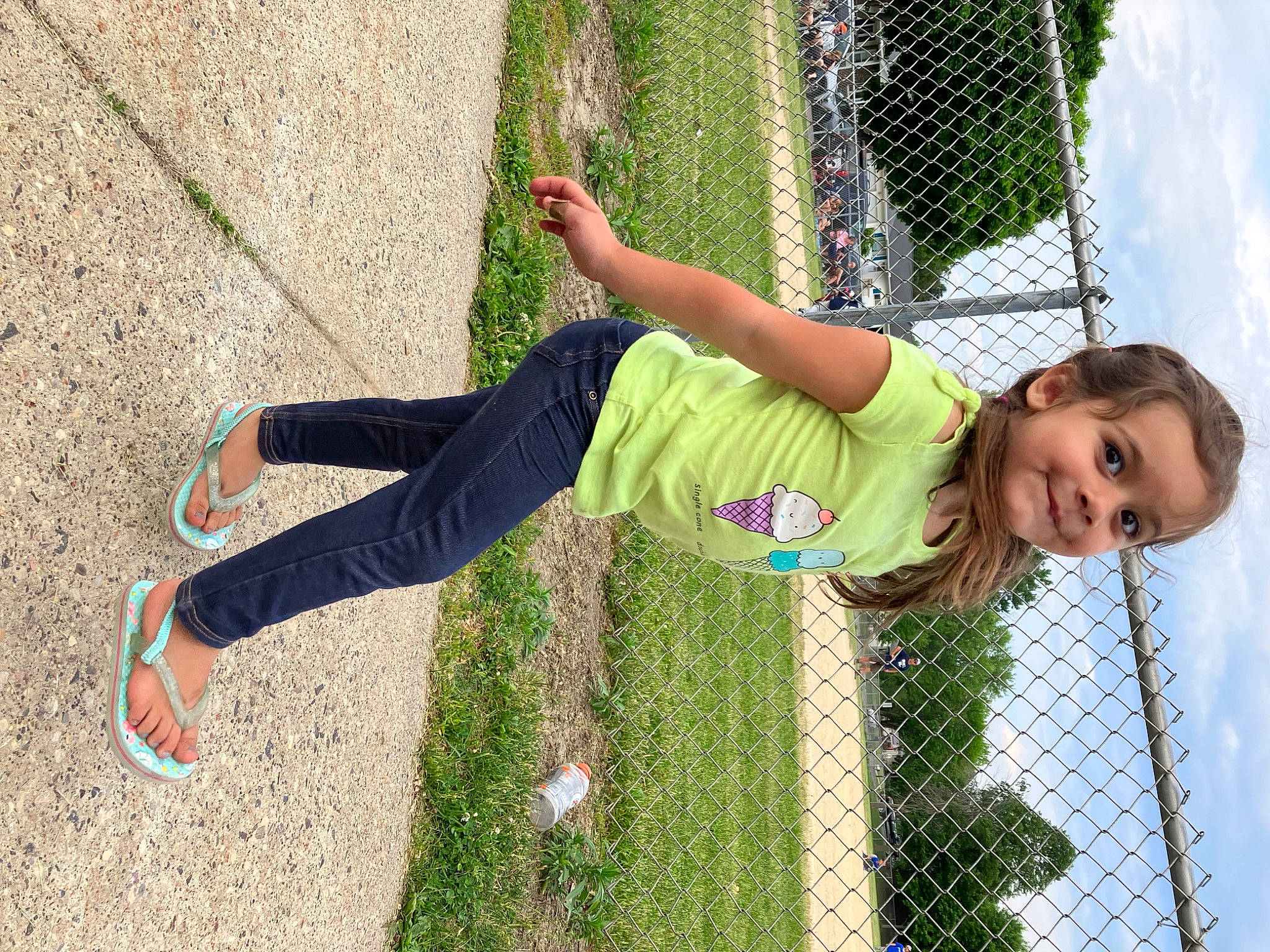London is registered to the contest to win money with this photo: child, cloud, fence, fun, grass, grass_family, happy, human_leg, joy, knee, leisure, mesh, outdoor_play_equipment, people_in_nature, person, play, recreation, sky, smile, spring