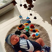 Jaziel is registered to the contest to win money with this photo: baby, sleeping, nike, onesie, hat, rug, knitted, toys, colorful, indoor, sunlight, window, soft, peaceful, child, infant, footwear, decorations, cushion, cozy